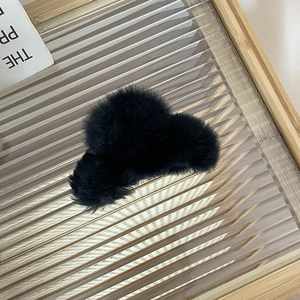 Large fluffy black rabbit fur claw clip with plush texture and elegant aesthetic style
