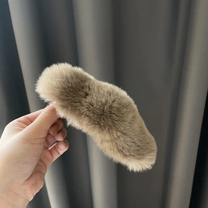 Detailed close-up of a large khaki faux fur hair claw clip with soft plush texture