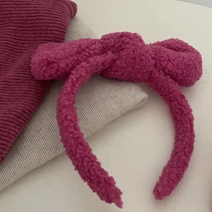 Roze teddy fleece haarband met strik voor een stijlvolle haarstijl met extra volume