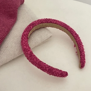 Detailweergave van de magenta tweed hoofdband met textuur en antislip binnenvoering