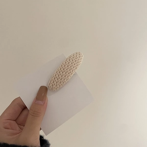 Barrette BB ovale en tricot beige avec texture présentée sur une carte