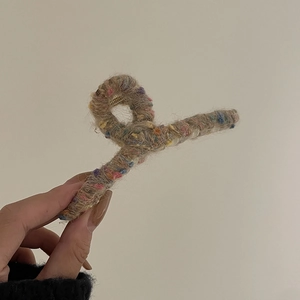 Détail de la pince à cheveux en tweed arc-en-ciel montrant le tissu en laine et le ressort