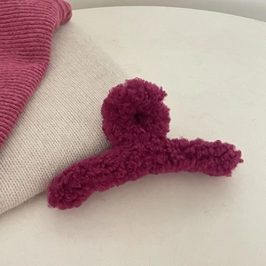 Detail van een pluchen haarklem van magenta teddywol met zachte lamsachtige stof