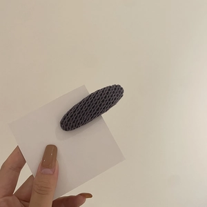 Détail de la texture tricotée violet foncé de la pince à cheveux ovale sur carte