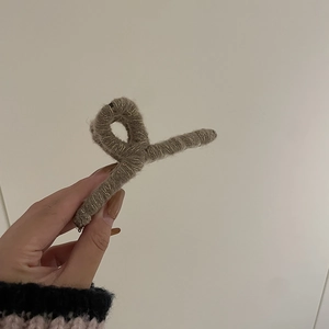 Vue détaillée d'une pince à cheveux en maille taupe faite main avec fils dorés brillants