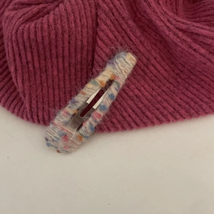 Gros plan détaillé d'une barrette BB en laine tricotée arc-en-ciel à texture douce