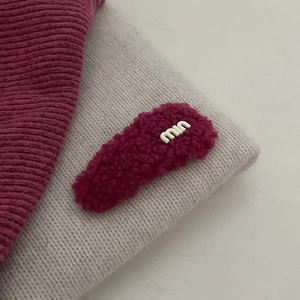 Detail van de pluche fuchsia tweed haarclip met witte geborduurde letters voor vrouwen