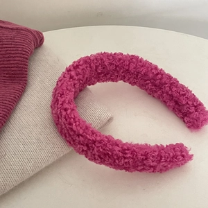 Detail van dikke roze tweed hoofdband met zachte pluizige textuur op gebreide stof
