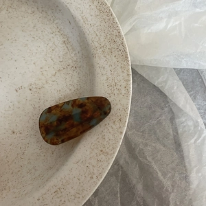 Detailed macro view of the tortoise shell acetate hair clip with brown and blue marble textures