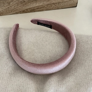 Handmade high padding velvet headband in soft pink on a cozy knit background