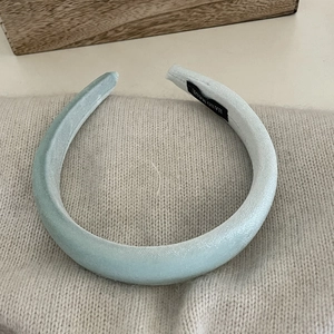 Detail of high-quality velvet padded headband with 'HAND MADE' label on wood tray