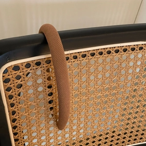 Vue détaillée du serre-tête éponge tricoté marron caramel sur une chaise en rotin