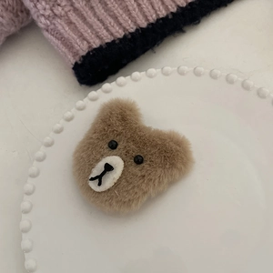 Pince à cheveux ours en peluche marron sur assiette en céramique pour coiffure hiver