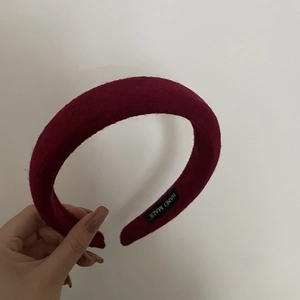 Detail showing hand made label and plush burgundy wool fabric texture on thick headband