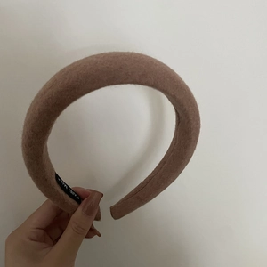 Detail view of handmade brown wool headband showing soft fabric texture and inner woven label