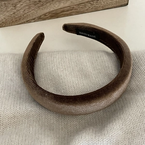 Detail of coffee brown velvet headband showing handmade label and premium texture