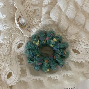 Dettaglio dell'elastico in feltro verde con puntini colorati su pizzo vintage chic
