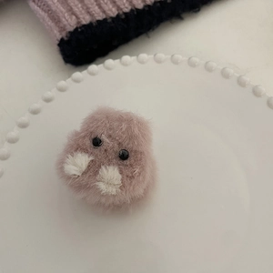 Détail d'un accessoire hamster en peluche lavande sur un plateau en céramique blanche