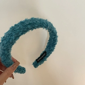 Détail du bandeau éponge bleu en peluche avec une étiquette tissée HANDMADE blanche