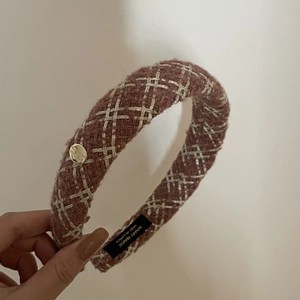 Detail of dusty rose tweed headband with thick padding and a golden Believe metal button