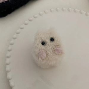 Détail d'une pince à cheveux chat en peluche mignonne sur une assiette en céramique