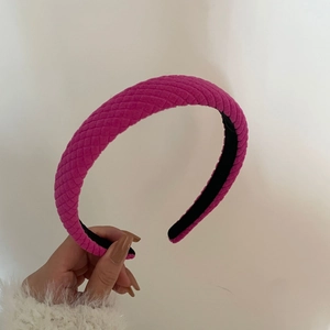 Close-up of fuchsia quilted sponge headband showing thick fabric texture and black lining