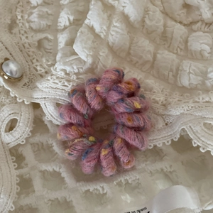 Macro di elastico per capelli a spirale intrecciato rosa con puntini colorati su pizzo