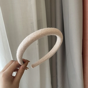 Close-up of thick beige fleece headband showing soft wool texture for autumn and winter