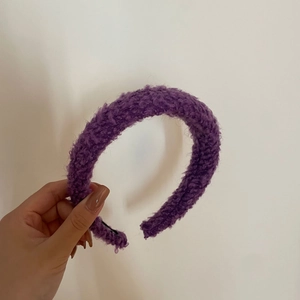 Gros plan sur un serre-tête en peluche violette avec une texture douce et épaisse