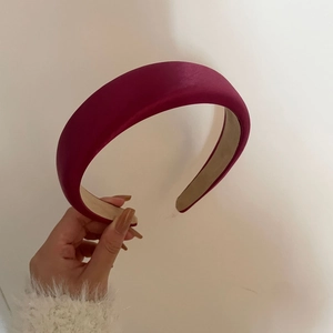 Macro detail of high-volume padded headband in elegant rose pink satin fabric