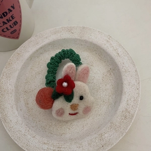 Detailed close-up of a handmade wool felt rabbit hair accessory with floral decorations