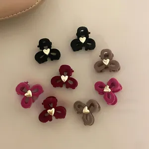 Detalle de pinzas para el cabello de terciopelo en cuatro colores y corazón dorado