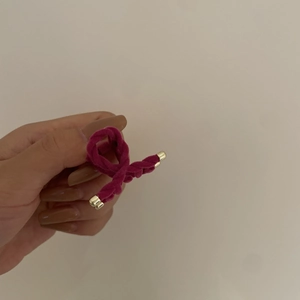 Dettaglio della clip per capelli in velluto rosa con punta in metallo dorato