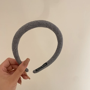 Detail showing grey knitted fabric texture and handmade label on the headband interior