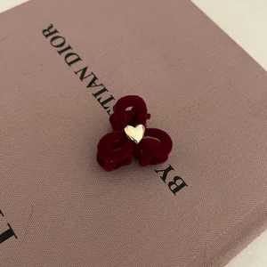 Detalle de una mini pinza para el cabello de terciopelo granate con un corazón dorado