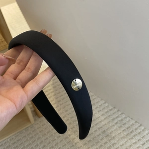 Elegant wide black satin padded headband with gold metal tag accessory for women