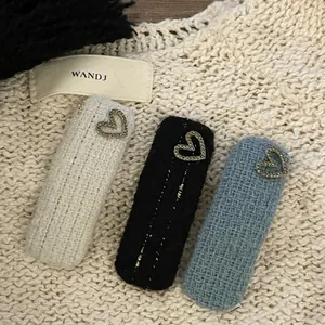 Three-piece tweed hair clip set with sparkling heart rhinestones on knit background