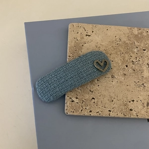 Detail of blue textured fabric hair clip with a sparkling silver heart rhinestone ornament