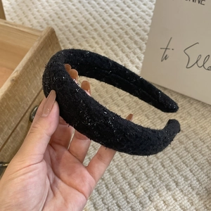Close-up of black padded headband with silver sequins and thick tweed knit texture