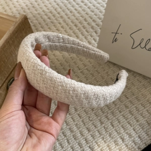 Detailed view of beige tweed headband with subtle sequins and thick knitted texture