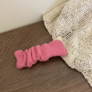 Barrette à cheveux rose plissée sur table en bois au style élégant et minimaliste