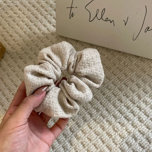 Elegant cream knit hair scrunchie with silver glitter threading and a textured finish