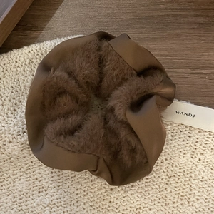 Brown faux fur and satin scrunchie hair tie on cozy knit background for high ponytail