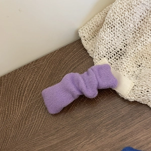 Détail de la texture en tissu plissé violet doux sur une pince à cheveux de style coréen