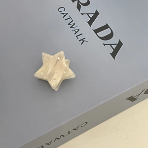 Detail of cream marble star hair claw clip with rhinestones on a fashion book cover