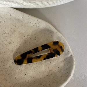 Elegant tortoiseshell acetate hair clip in a water drop shape with deep brown amber texture