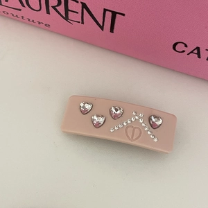 Pink heart crystal hair clip with pavé rhinestones on elegant designer background