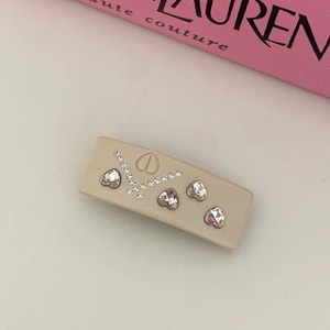 Elegant beige heart rhinestone hair clip with luxury logo and shimmering crystal details