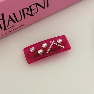 Detailed macro view of the rectangular rose pink hair clip with sparkling heart rhinestones