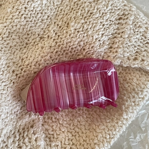 Detail of pink acetate shark hair claw with France Handmade gold text and striped texture